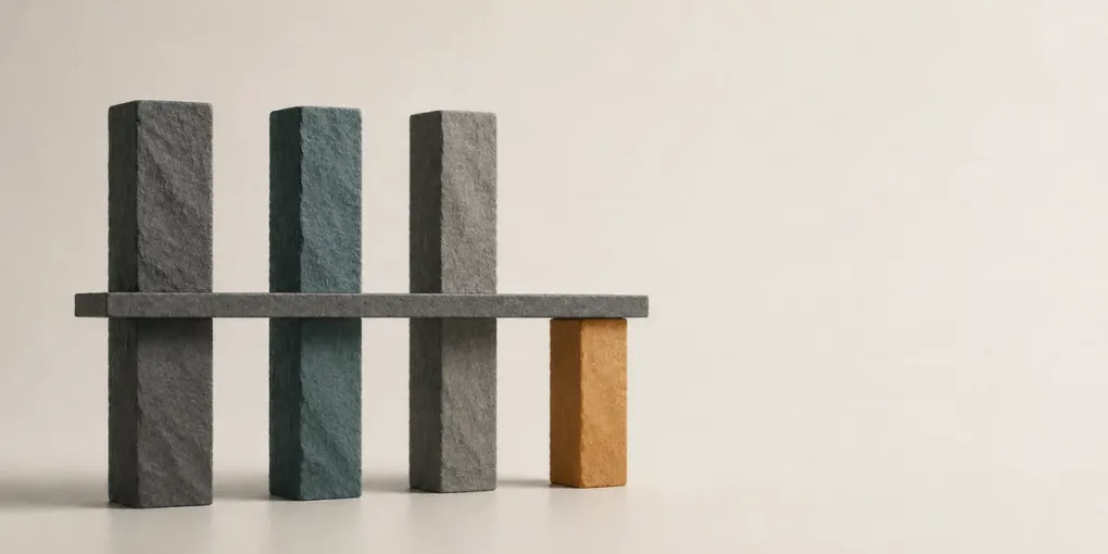Four stone pillars of unequal height; a level slab rests on the shortest one while the three taller pillars rise unused above it