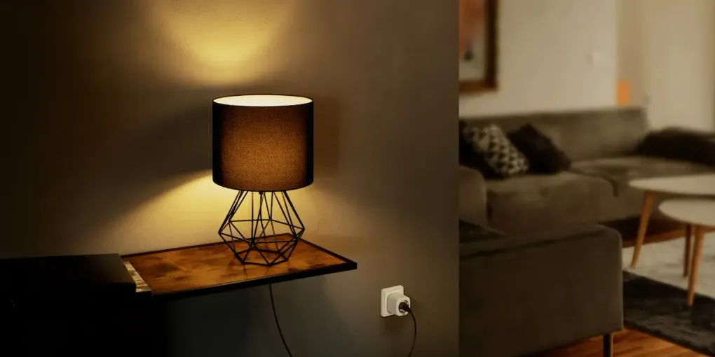 A table lamp powered through a white Eve Energy smart plug in a living-room wall outlet (Eve Systems press photo)